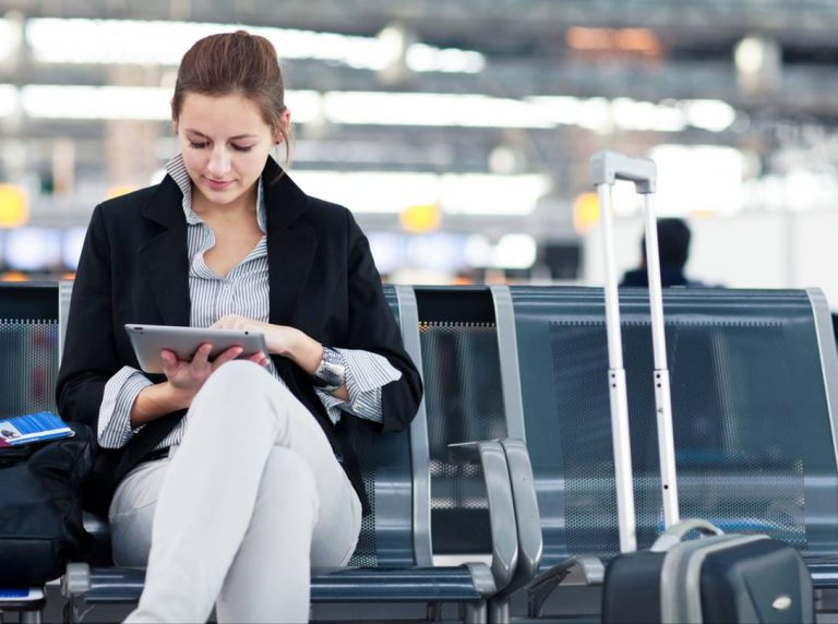 Woman in airport lounge reading on a tablet